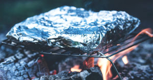 Papillotes en papier d'aluminium sur la flamme d'un BBQ